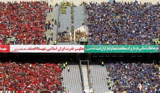 Supporters of Esteghlal (right) and Persepolis (left) cheer during their Persian Gulf Pro League derby football match at the Azadi Stadium in September 2016.