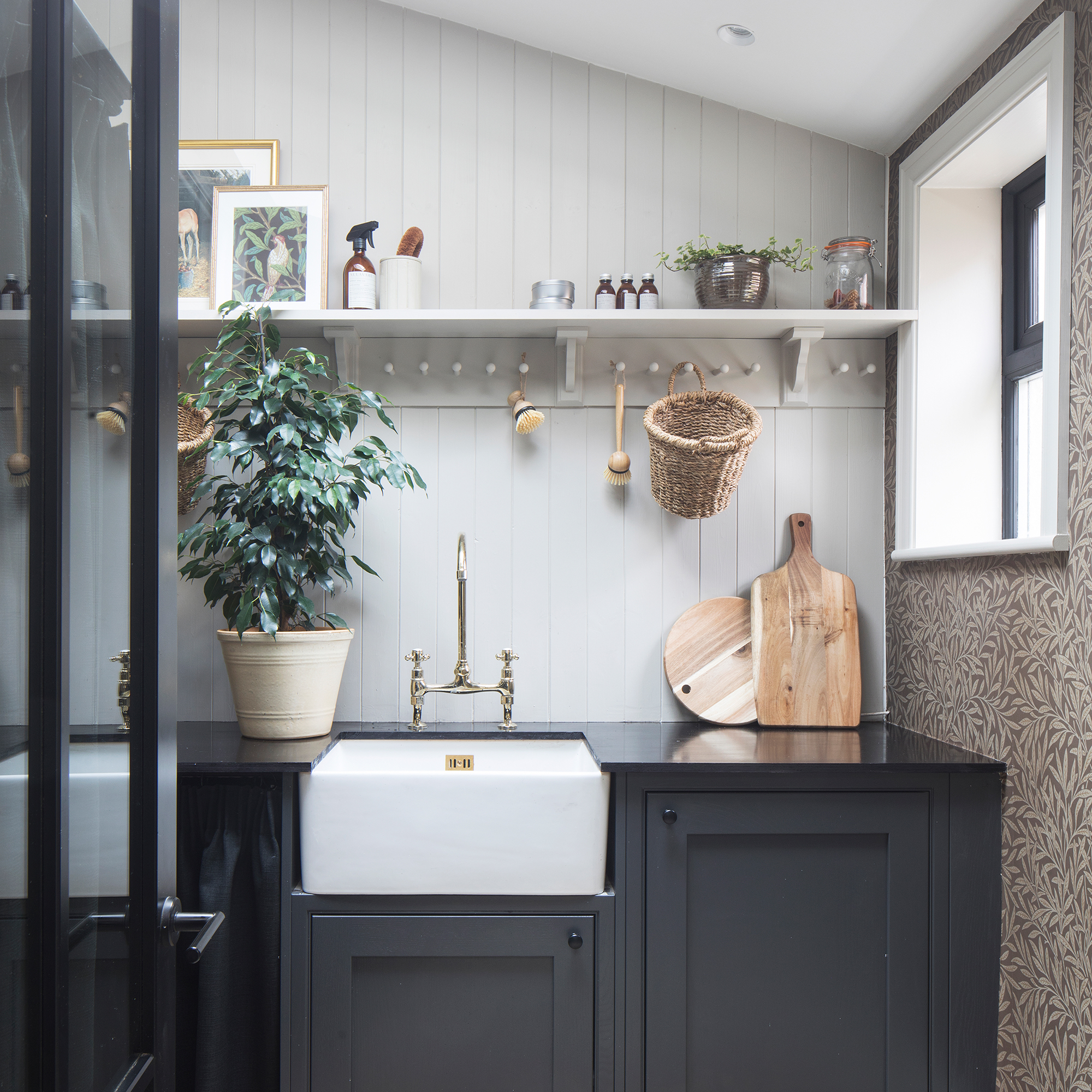 Utility room with dark grey cabinetry, wall panelling and wallpaper