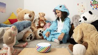 Child surrounded by teddies with an Amazon Echo Dot smart speaker