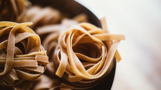 Whole wheat pasta in a bowl, a representation of complex carbohydrates to lower your metabolic age