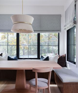 A dining room seating alcove with two benches and a sculptural pendant