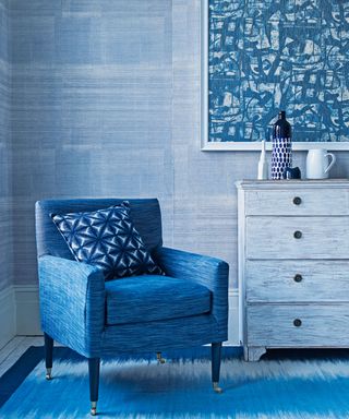 Blue and white bedroom with armchair and chest of drawers