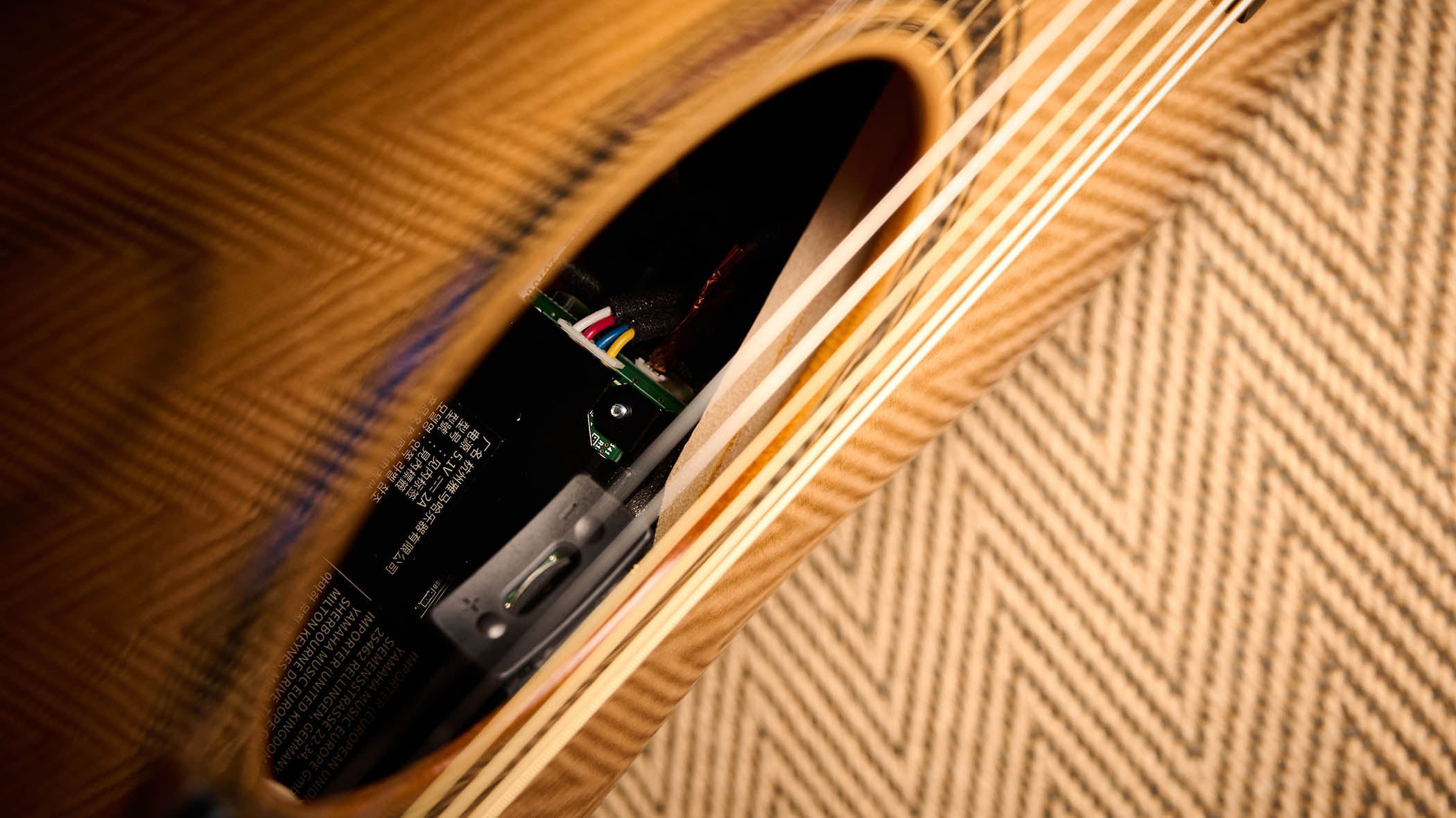 The Yamaha TransAcoustic TAG3 C is a cutaway acoustic guitar with a sandburst finished, photographed in closeup