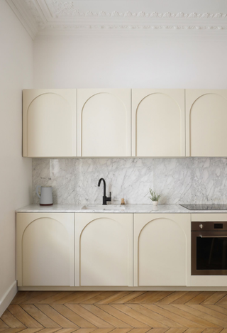 A tiny one wall kitchen that has symmetrical cabinets showing a geometric design