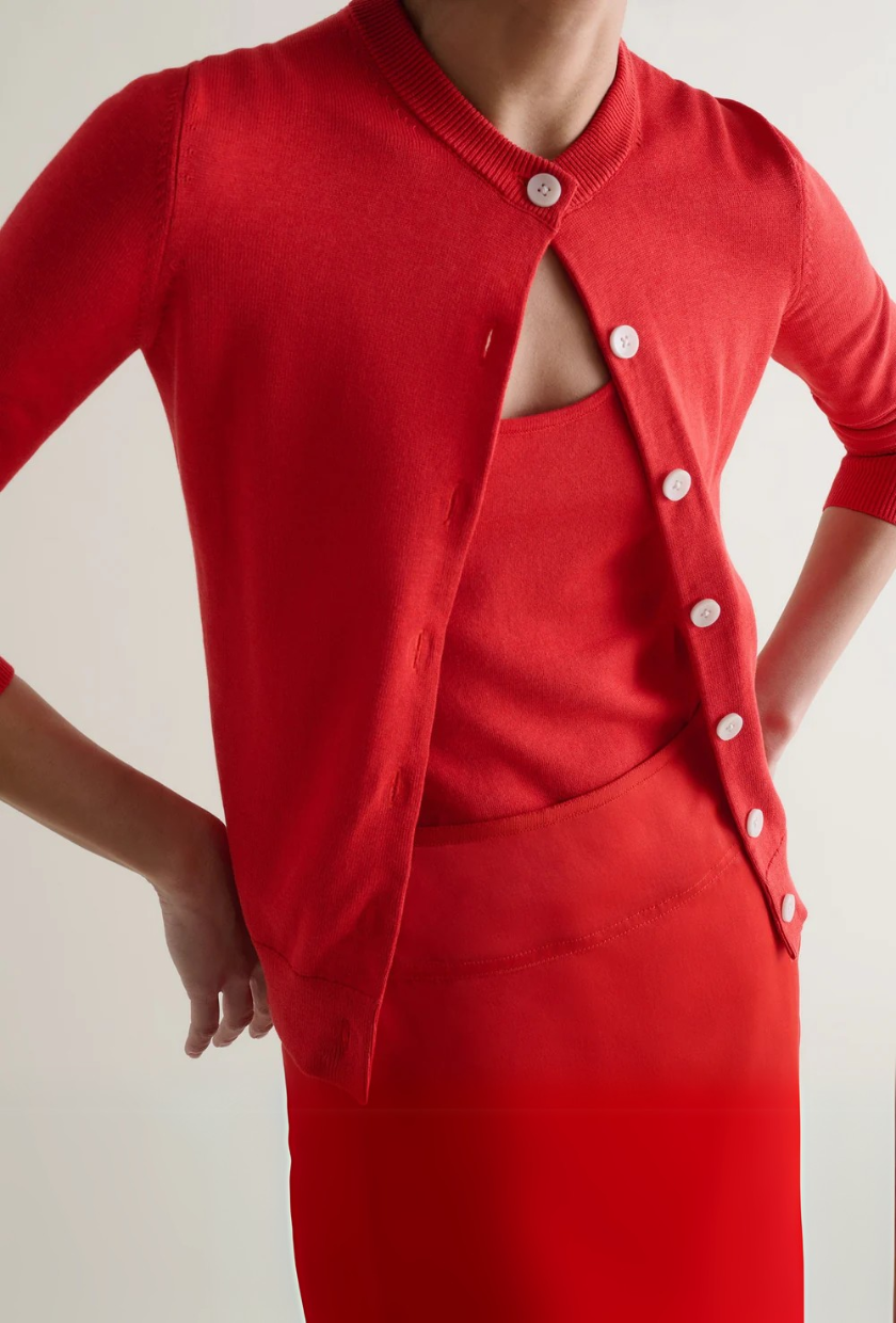 An image of a red fine-knit cardigan from Rise & Fall.