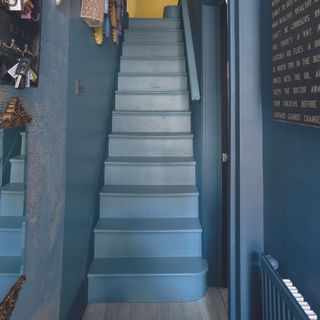 Navy hallway with matching stairs and walls.