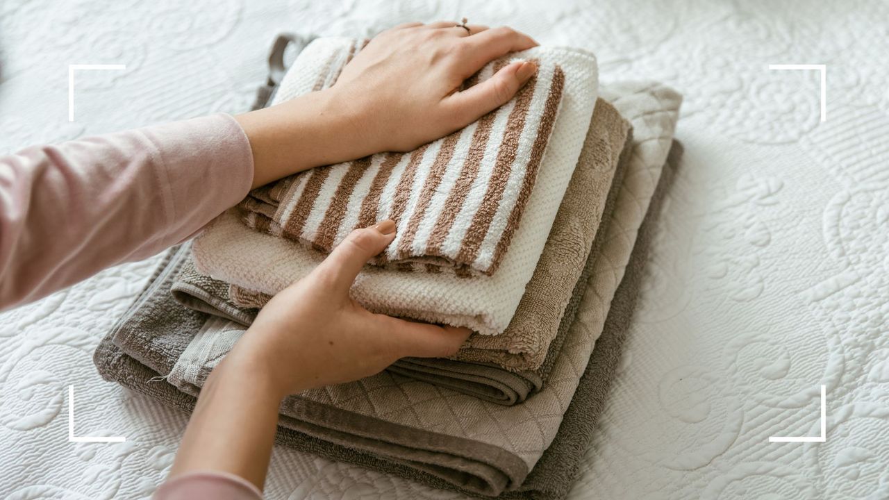 picture of woman folding clean laundry to support the aspirin laundry hack 