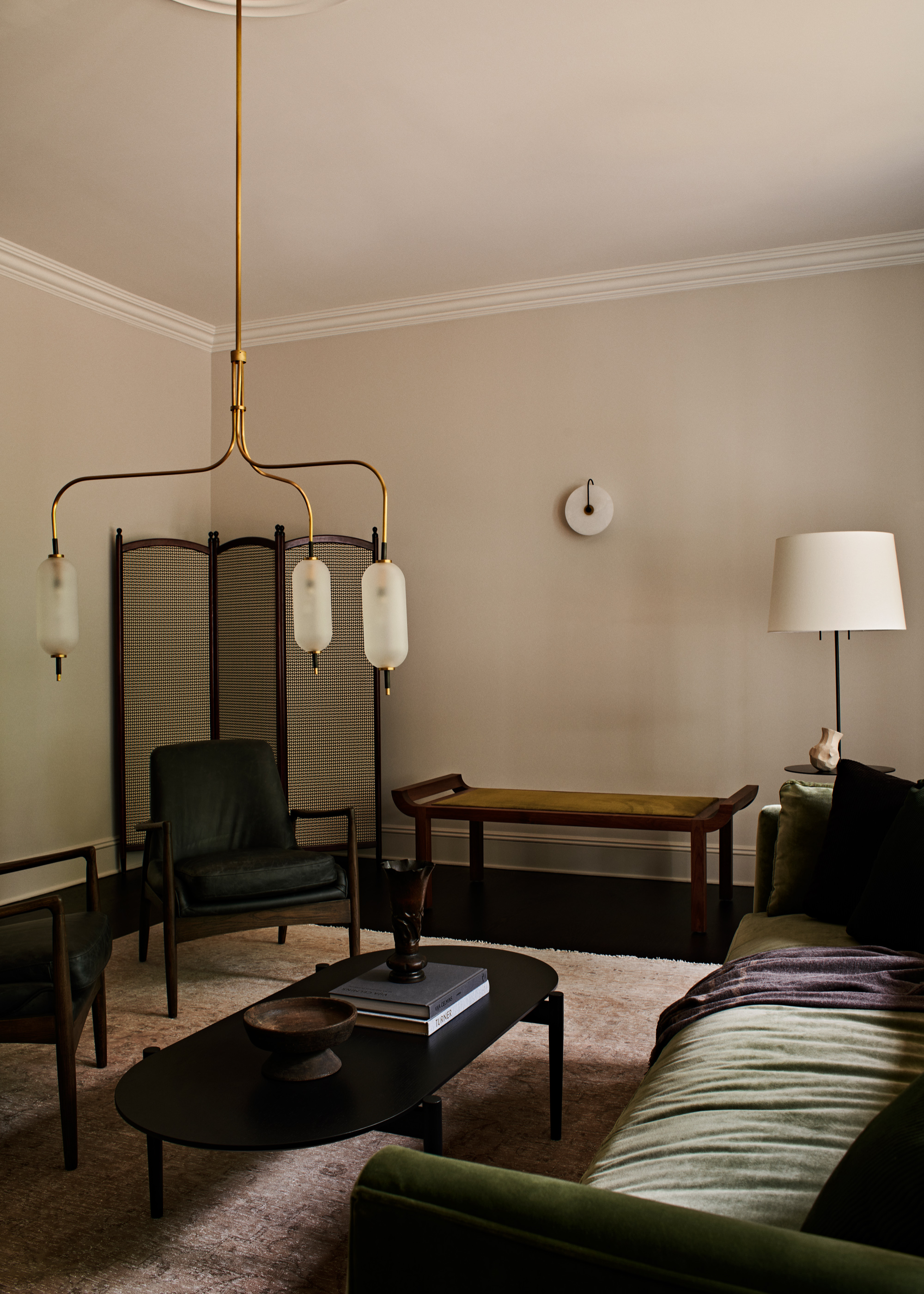 A living room chandelier hung low over the coffee table