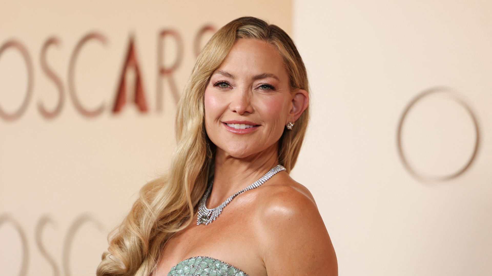 Kate Hudson is pictured wearing a jade dress, with her hair styled to the side and with radiant, rosy makeup at the 98th Annual Academy Awards at the Dolby Theatre in Hollywood, California on March 15, 2026. 