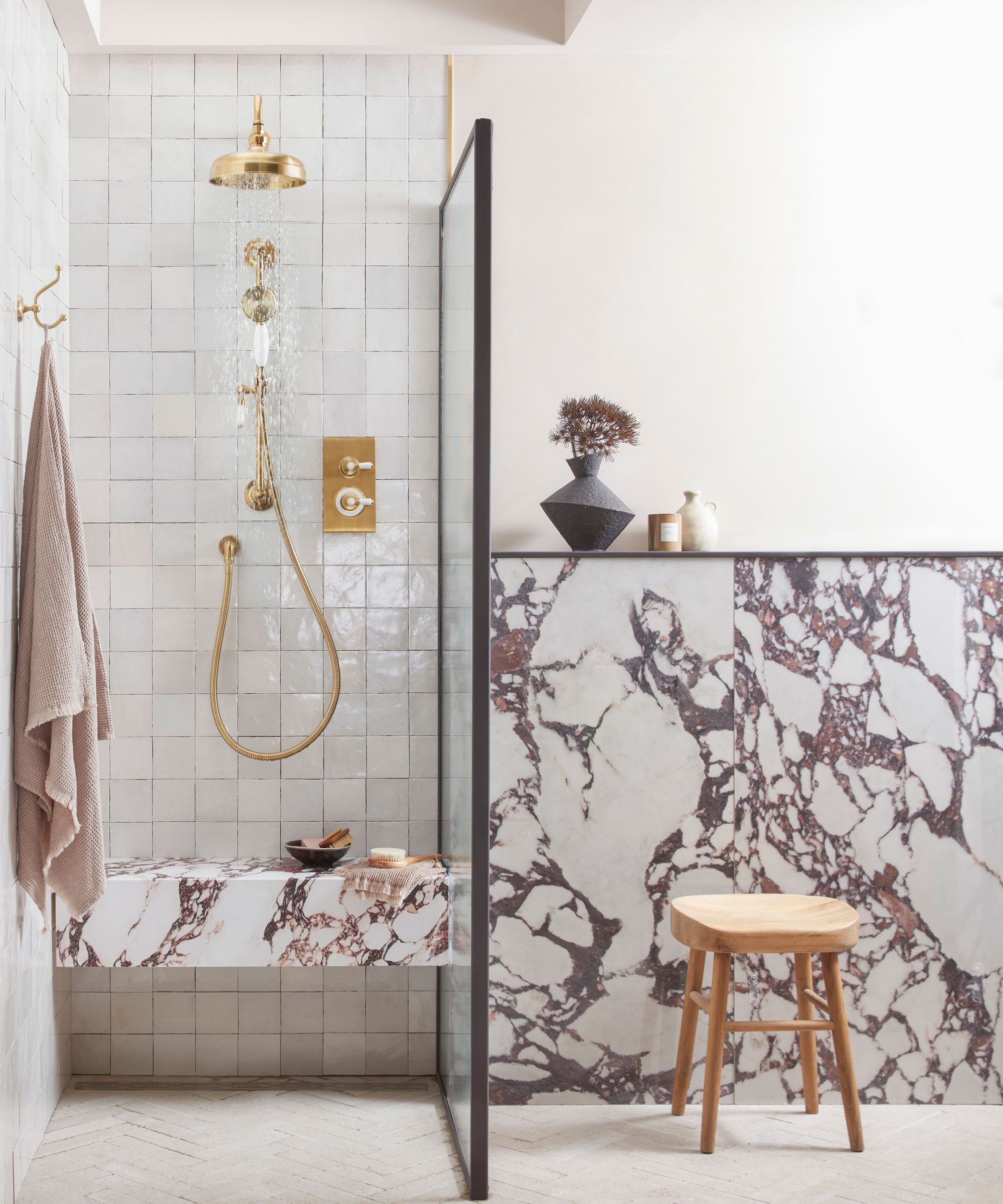 marble bathroom with walk-in shower with brass shower fittings