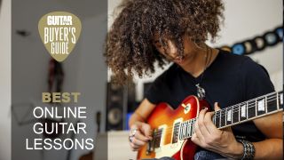 Young man with long hair plays a sunburst finish single-cut guitar
