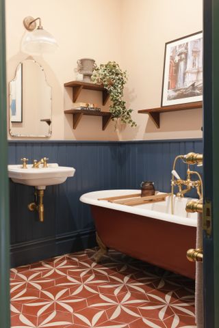 small bathroom with tongue and groove wood paneling, patterned floor and open floating shelves by Brooke Copp-Barton