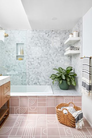 pink and gray bathroom, graphic pink tiles, gray hex tiles, freestanding vanity, open shelving, basket