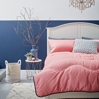 bedroom with white and blue walls and printed pink duvet set