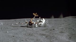 Astronaut John W. Young drives the Lunar Roving Vehicle during the first of three Apollo 16 extravehicular activities.