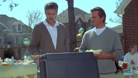 Tim Robbins and Jeff Bridges talking at a grill in Arlington Road