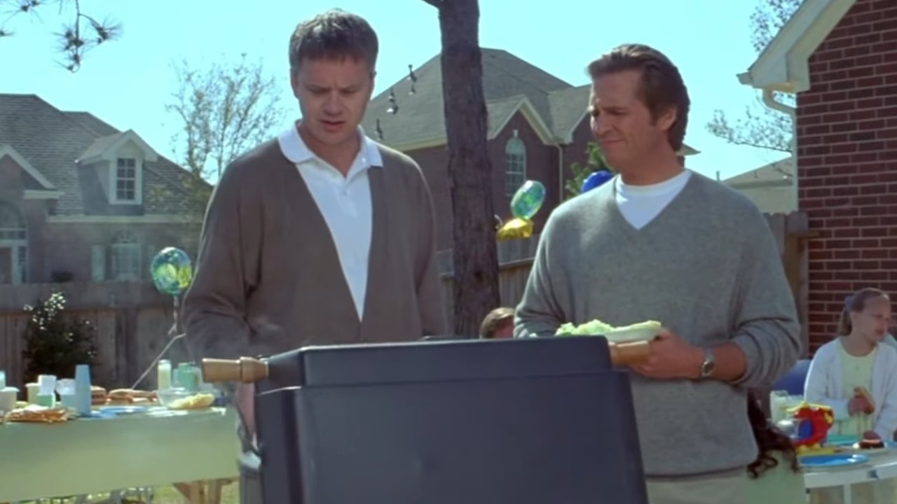 Tim Robbins and Jeff Bridges talking at a grill in Arlington Road