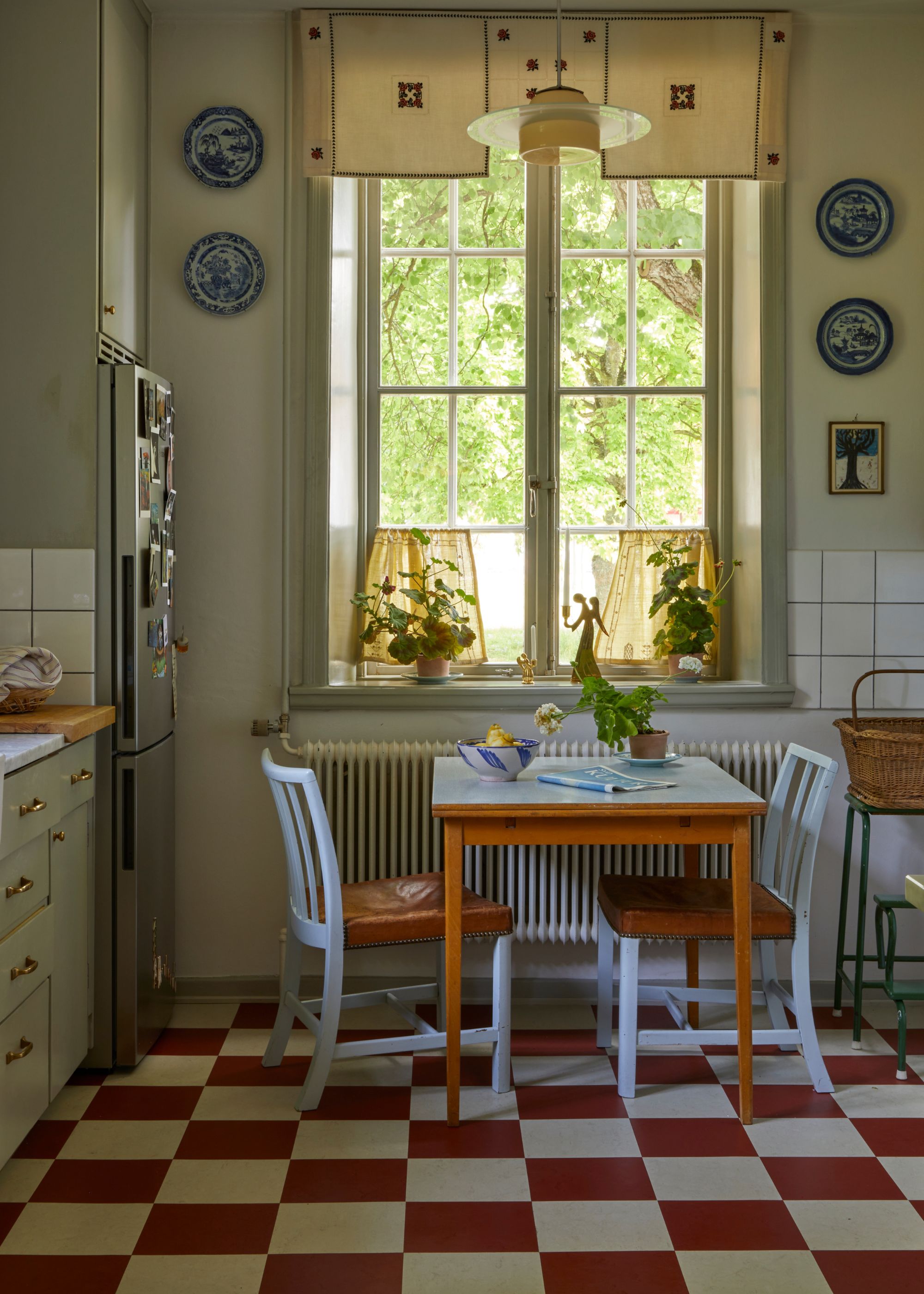 A red and white checkered flooring with a baby blue painted dining table and chairs.