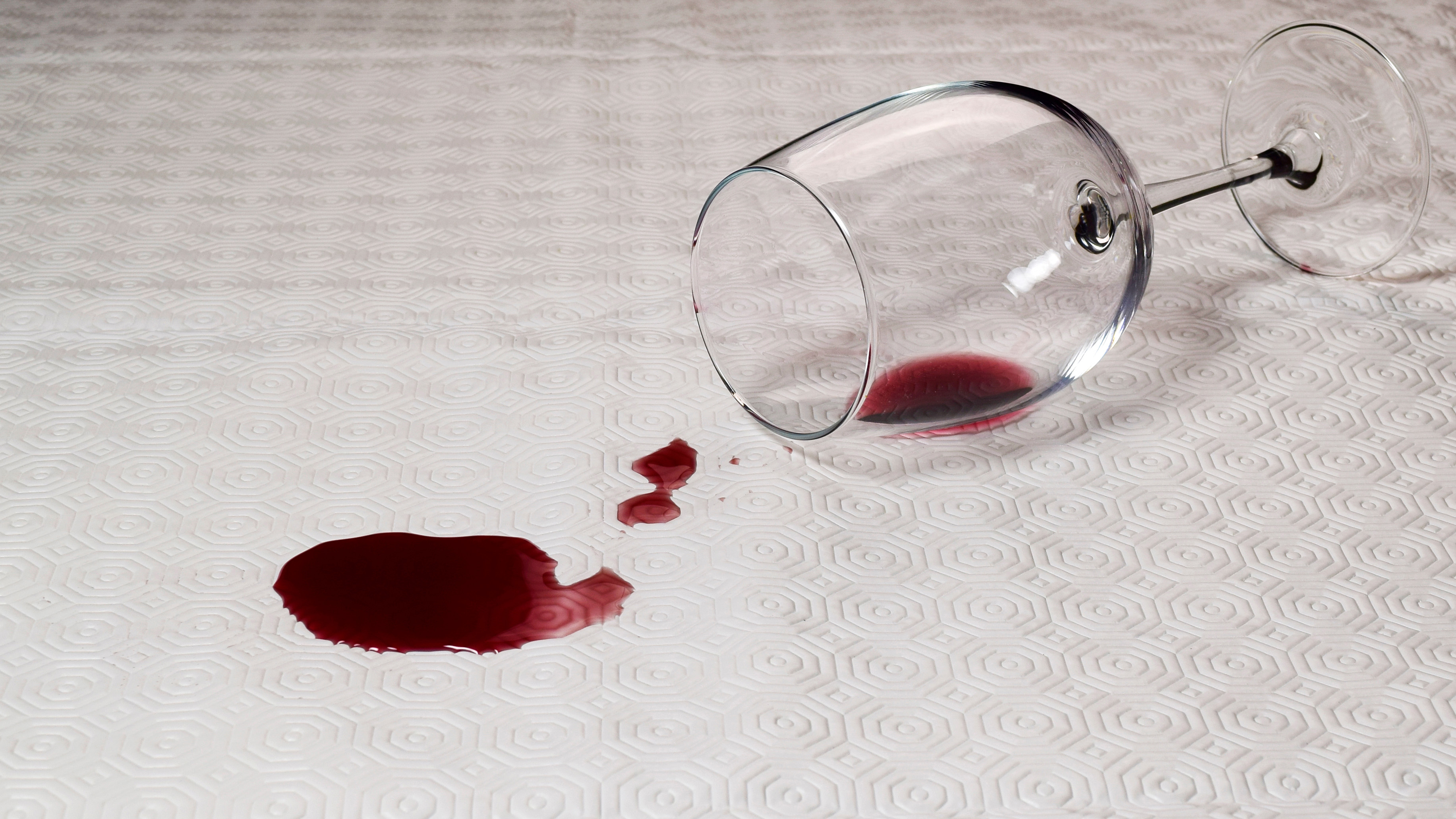 A glass of spilled red wine