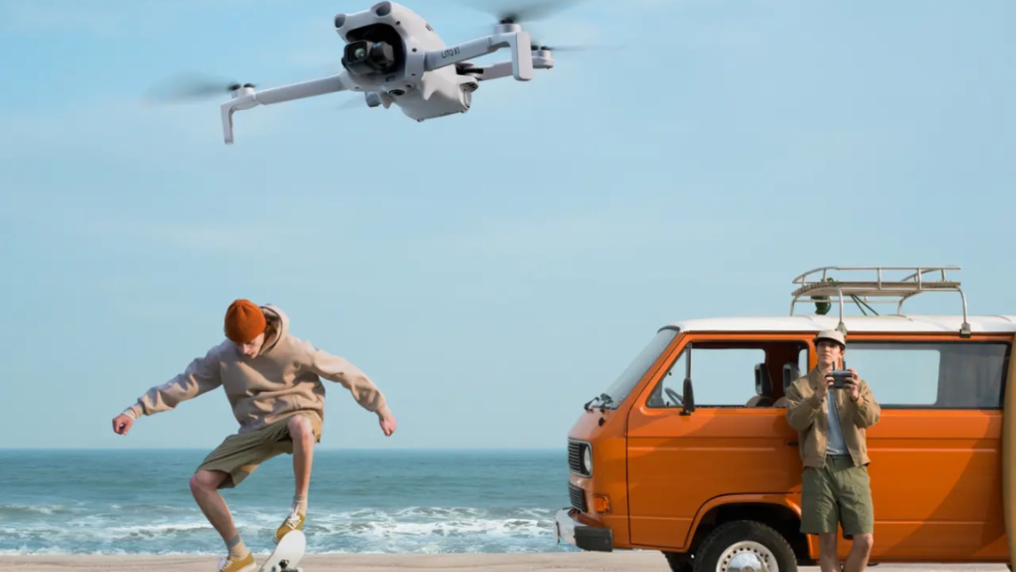 Man riding skateboard while other operates drone