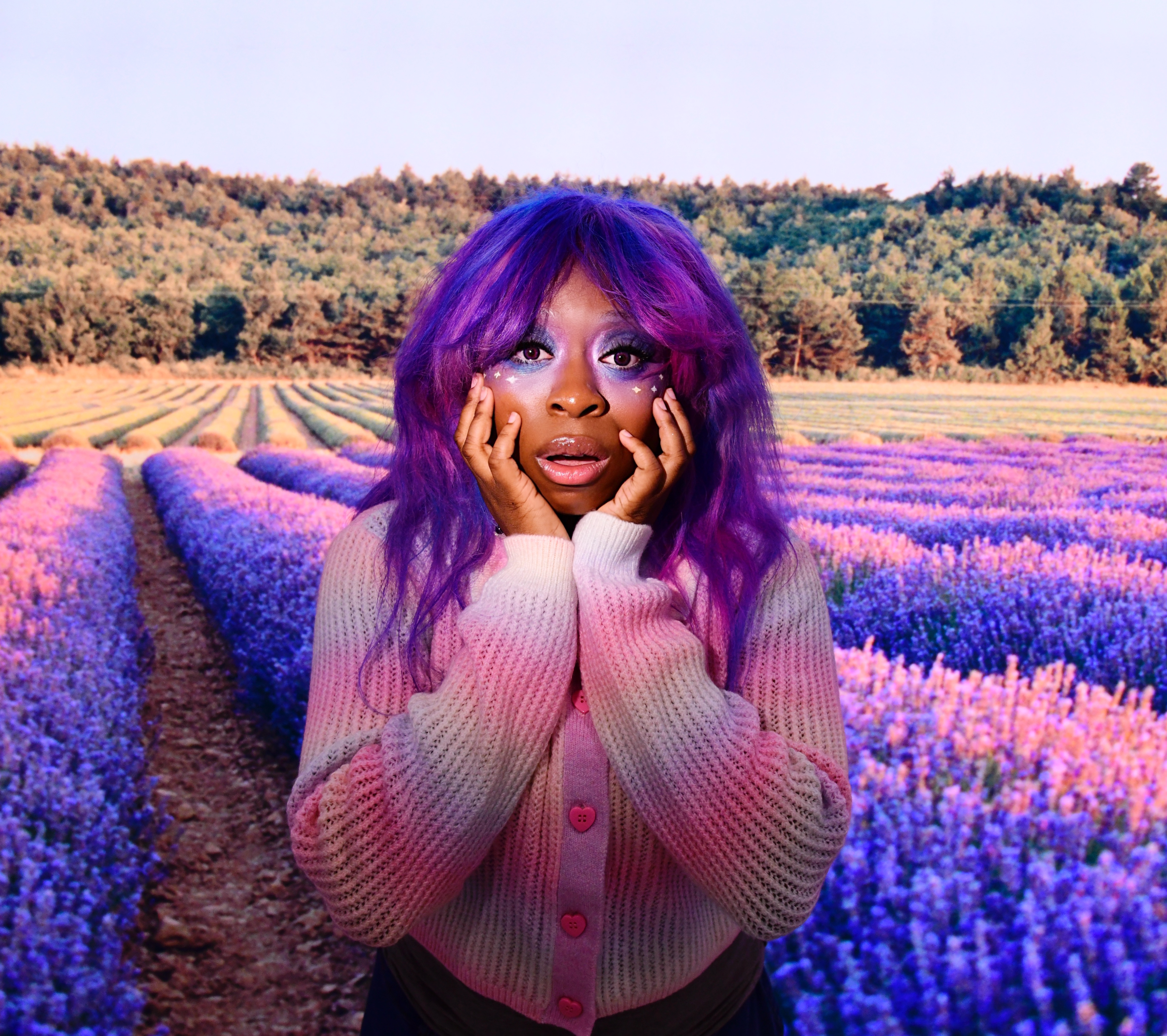 hemlocke springs poses in a colorful flower field with purple colored hair