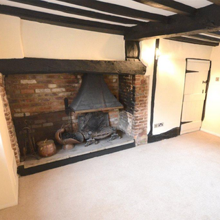 fireplace with brick wall and wooden beams on ceiling
