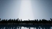 a bright beam of light obscures stars in a night sky above a silhouette of a tree line by a lake