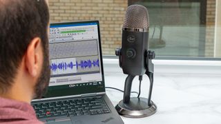 Hero image for best USB microphones showing Blue Yeti X mic with laptop