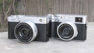 Silver Fujifilm X-E5 alongside the Fujifilm X100VI, on a wooden bench