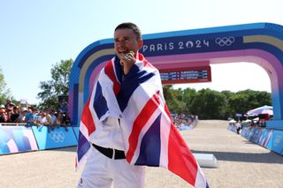 ELANCOURT FRANCE JULY 29 Gold medalist Thomas Pidcock of Team Great Britain bites his medal during the Mens CrossCountry on day three of the Olympic Games Paris 2024 at Elancourt Hill on July 29 2024 in Elancourt France Photo by Alex BroadwayGetty Images
