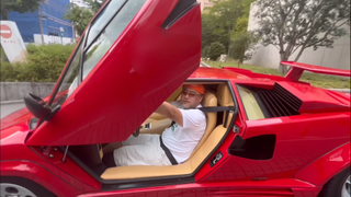 Hideki Kamiya sits in the driver's seat of a Lamborghini, door open.