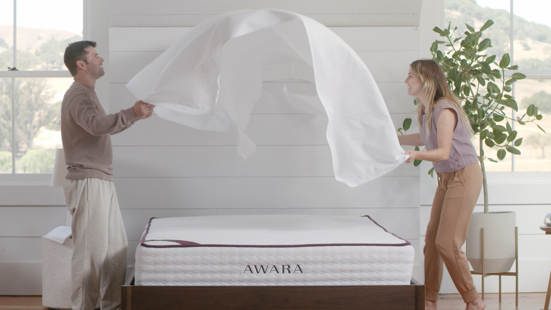 Awara mattress with couple putting a sheet on top