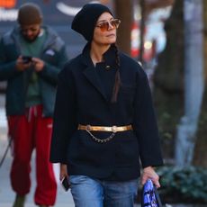 Katie Holmes wears a blue peacoat with a gold belt and jeans while walking around new york city for her birthday