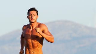 Man running in the mountains without a watch, headphones, or a shirt