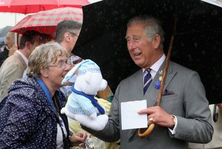 King Charles III holds a teddy bear from fans
