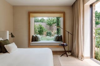 a modern bedroom with seat built into the window