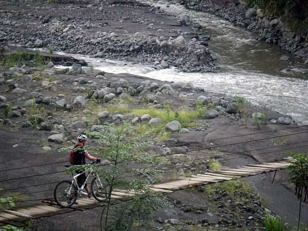 A rider crosses a bridge during stage three.