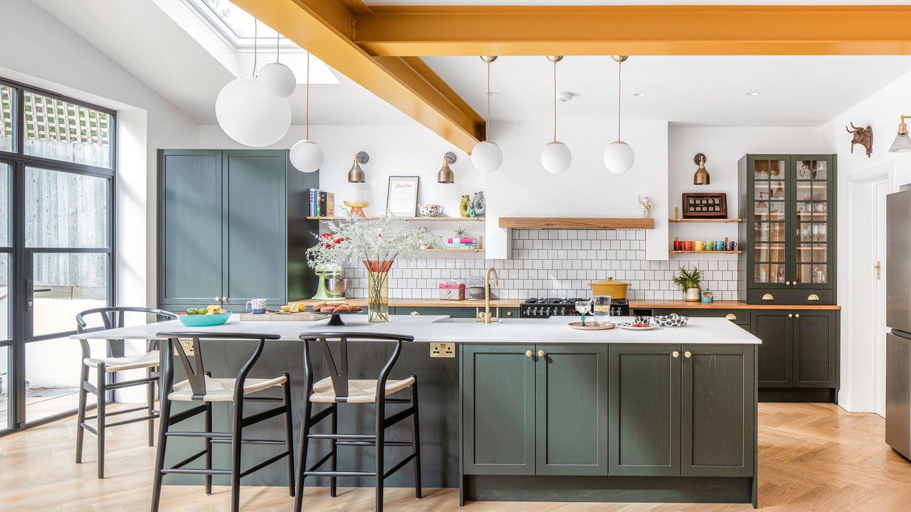 Kitchen island and open shelves iwith yellow beams above and wishbone style bar stoolsmixer