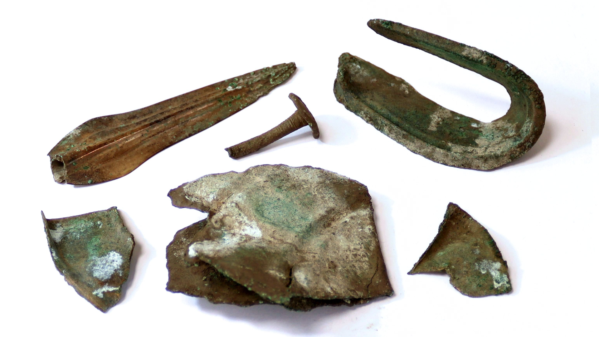 six bronze artifacts on a white background
