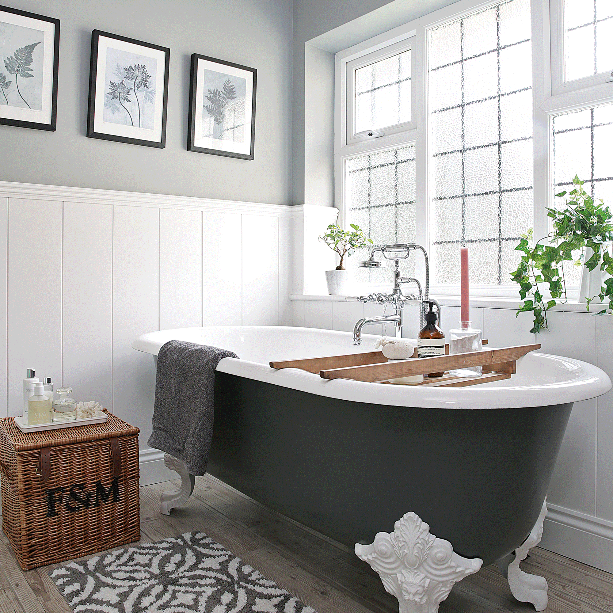 Black bathtub with white tiles and pictures