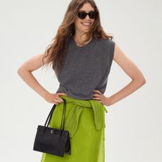 Woman in gray knit top and green skirt