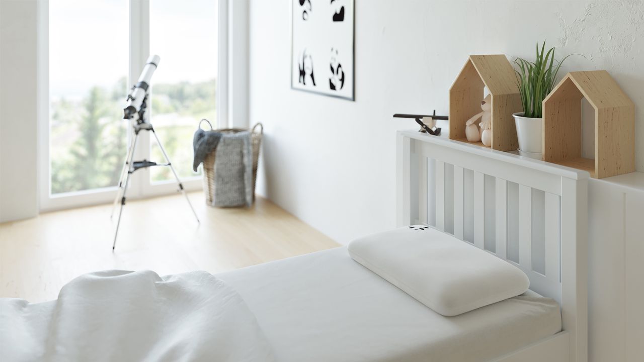 Child&#039;s bedroom with white bedding and telescope by the window