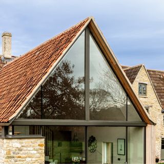 Glazed wall with fixed windows in stone clad home