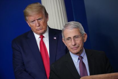 Director of the National Institute of Allergy and Infectious Diseases Anthony Fauci, flanked by US President Donald Trump, speaks during the daily briefing on the novel coronavirus, which cau