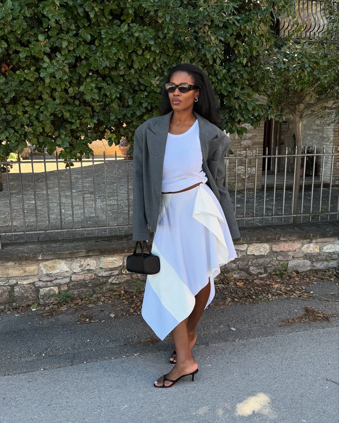 @nlmarilyn wears white skirt, blazer and black strappy mule sandals