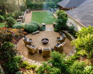 round gravel patio with fire pit in garden designed by Father Nature Landscapes