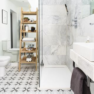 bathroom with white wall and wooden rack