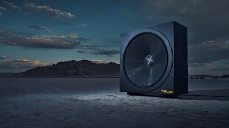 A promotional photo of the Deus Invicta 60 subwoofer on a dried lake bed underneath a late evening sky