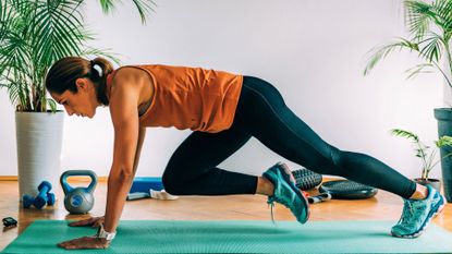 Lose weight at home: Image shows woman doing mountain climber ab move on a mat