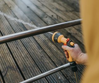 Cleaning a deck with a garden hose nozzle